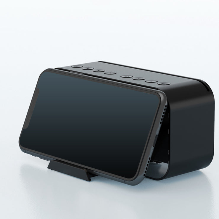 Black smartphone leaning against the front of the Portable Bluetooth Speaker using its sliding holder